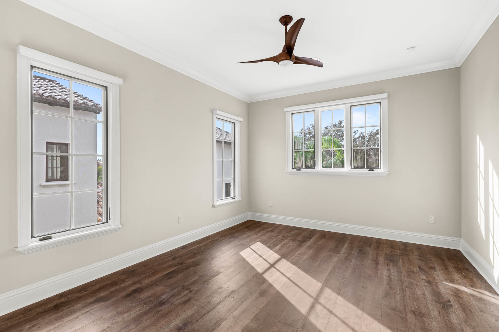 empty bedroom with wood plank floors and windows
